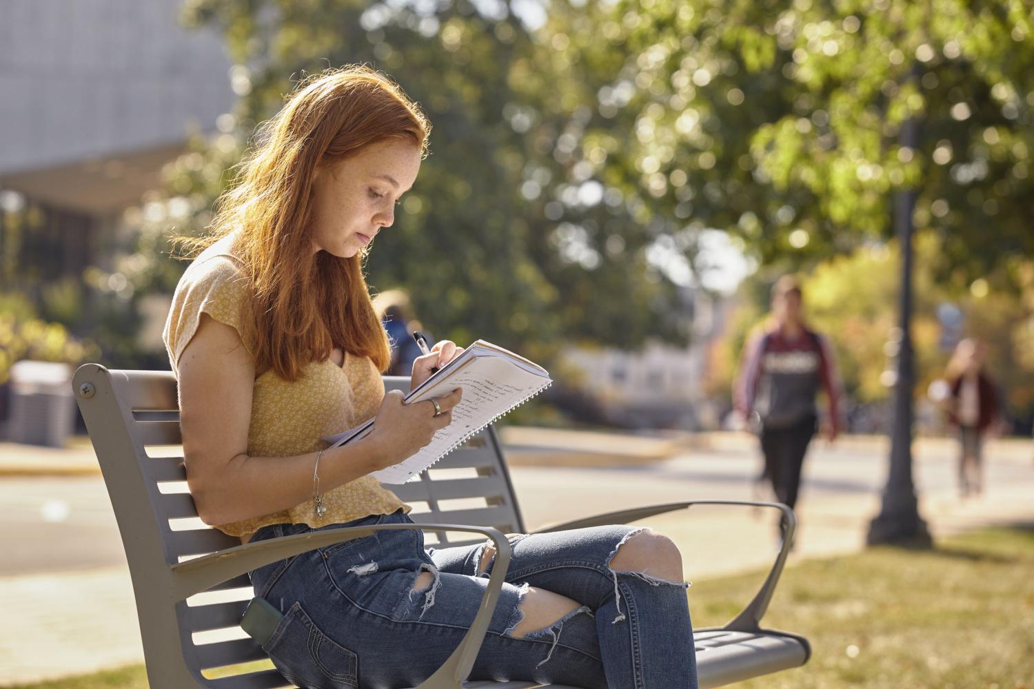 一位<a href='http://z6.lennonautostarting.net'>全球十大赌钱排行app</a>学院的学生在校园里的长椅上读书.